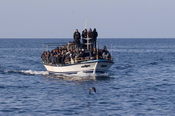 Un grupo de personas en una embarcación cruza el Mediterráneo rumbo a las costas de Italia