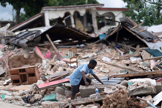 Un hombre busca entre los escombros tras el terremoto en Les Cayes, Haití