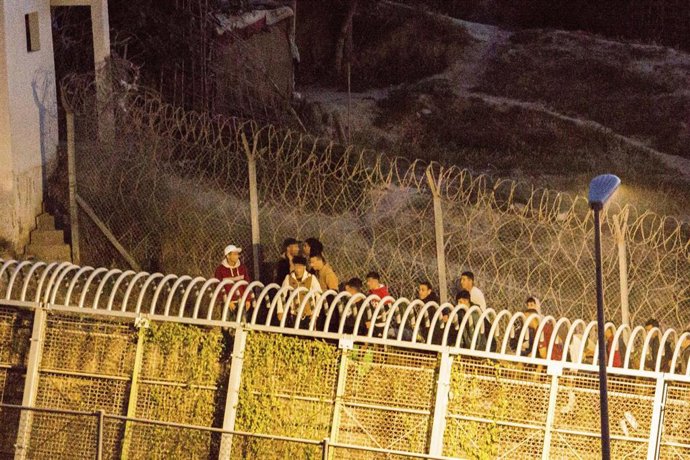 Archivo - Varios marroquíes intentan llegar a suelo español desde la frontera que separa Melilla y Marruecos