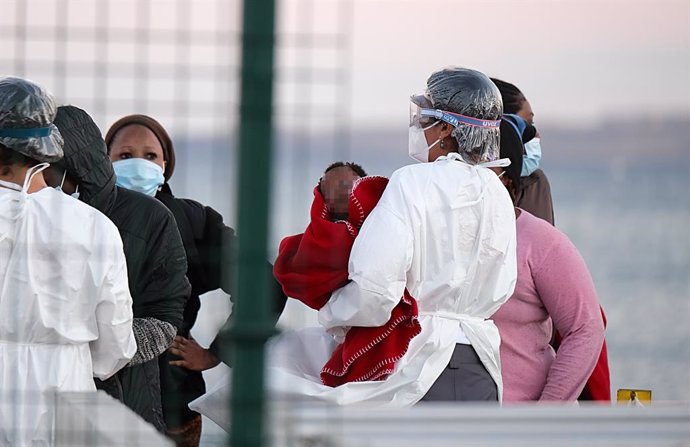 Archivo - Una sanitaria lleva en brazos a una niña que llega a tierra junto con otros migrantes tras el rescate del buque Salvamar Mizar a una patera de 56 inmigrantes subsaharianos, entre ellos dos bebés y es posible que alguna mujer embarazada, en el 