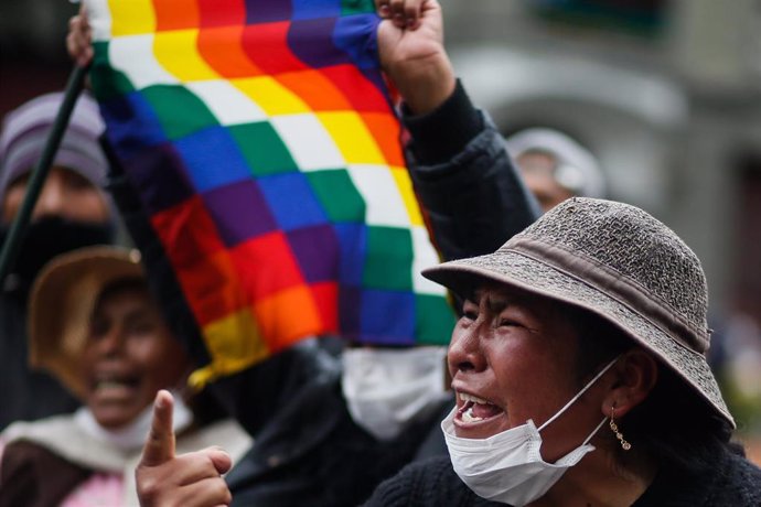 Archivo - Una seguidora de Morales con una bandera whipala durante las manifestaciones en Bolivia