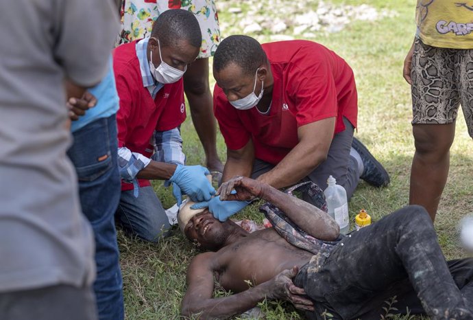 19 August 2021, Haiti, Maniche: Medical workers treat an injured man at a mobile medical clinic, set up by Kansas City-based Heart to Heart International, in a compound outside the office of the mayor of Maniche near the epicentre of the earthquake. Wit
