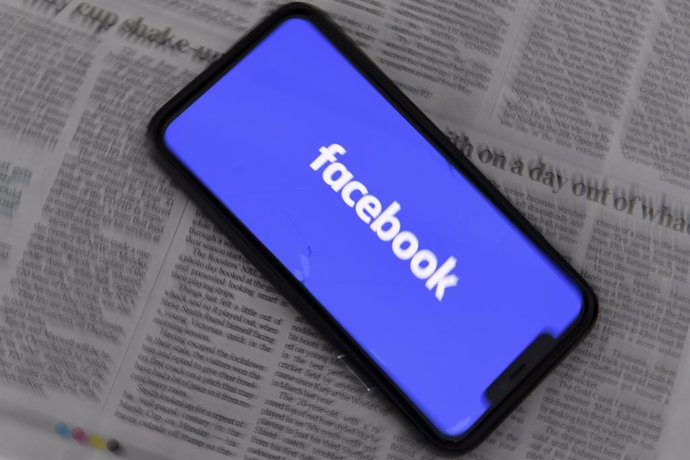 Archivo - An illustration image shows a phone screen with the Facebook logo seen at Parliament House in Canberra, Thursday, February 18, 2021. Social media giant Facebook has moved to prohibit publishers and people in Australia from sharing or viewing