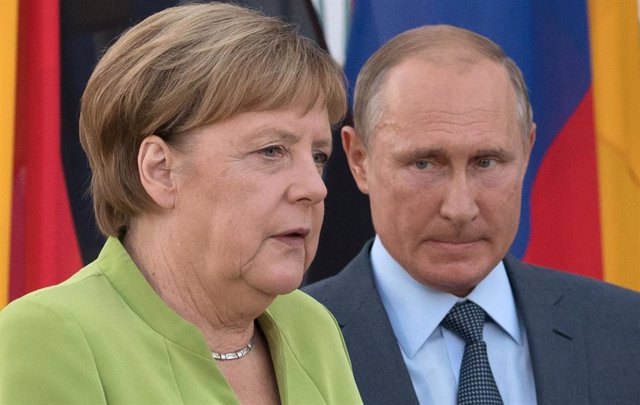 Archivo - FILED - 18 August 2018, Brandenburg, Meseberg: Russian President Vladimir Putin (R) and German Chancellor Angela Merkel arrive for a joint press conference in in Meseberg. German Chancellor Angela Merkel is to meet Russian President Vladimir Put