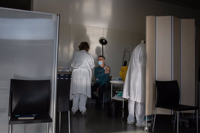 Archivo - Arxivo - Una infermera bovina a un professional sanitari amb la vacuna de Pfizer-BioNtech contra el COVID-19 a l'Hospital de la Santa Creu i Sant Pau de Barcelona.