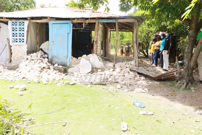 Varias personas observan los daños causados en un edificio tras el terremoto en Haití