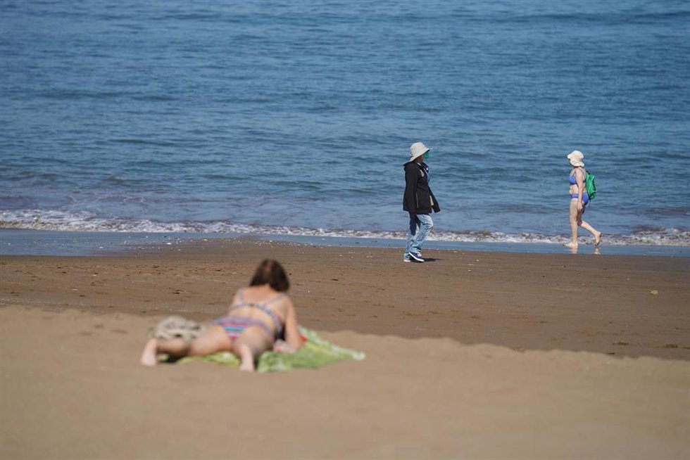 Archivo - Varias personas pasean y toman el sol en la Playa de Ereaga en Getxo
