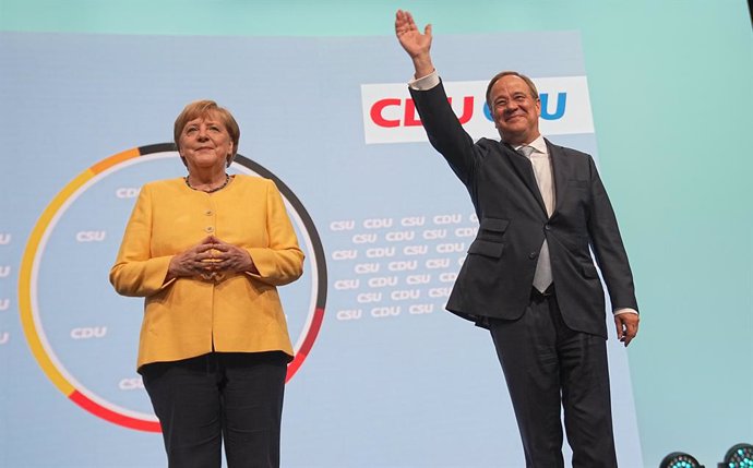 21 August 2021, Berlin: German Chancellor Angela Merkel (L) and Armin Laschet, Minister-President of North Rhine-Westphalia, leader of the Christian Democratic Union (CDU) and candidate for Chancellor, stand on stage at the kick-off of the CDU/CSU's cen