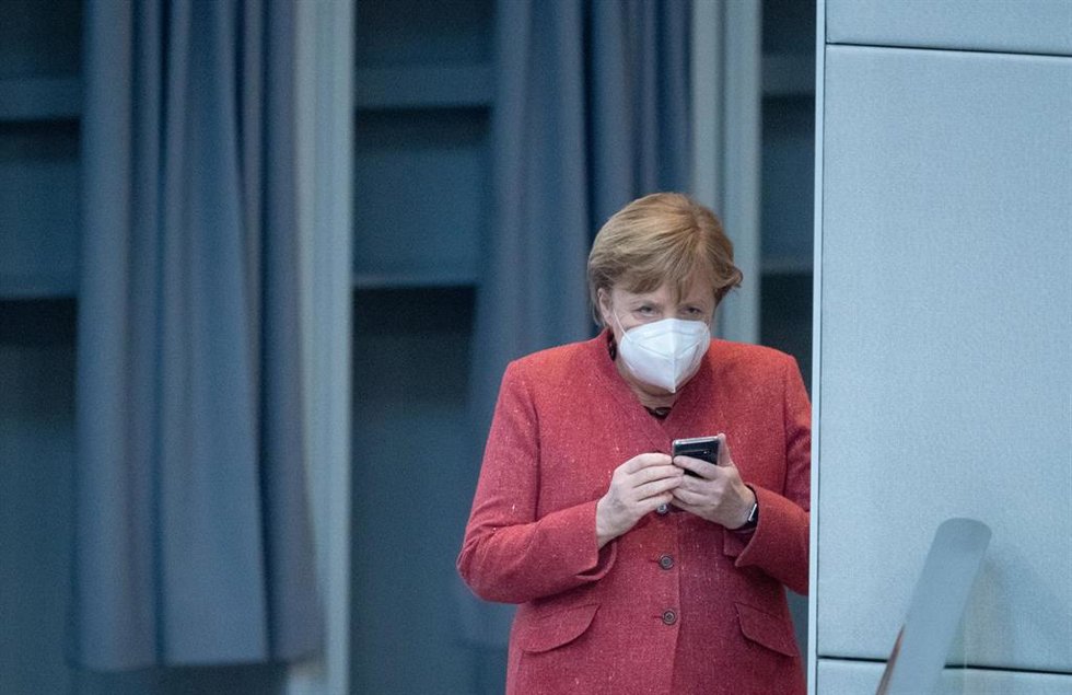Archivo - Angela Merkel revisa su teléfono móvil en el Bundestag