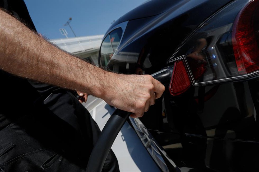 Una persona recarga un coche eléctrico en un punto de recarga