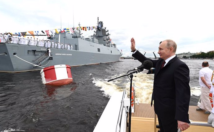 HANDOUT - 25 July 2021, Russia, St. Petersburg: Russian President Vladimir Putin waves to soldiers sailing past during a naval parade at the Neva River to mark the Russian Navy Day. Photo: -/Kremlin/dpa - ATTENTION: editorial use only and only if the cr
