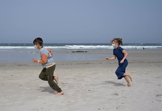 Archivo - Unos niños con mascarilla en una playa de la provincia de A Coruña