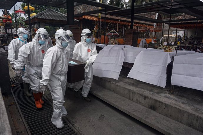 02 August 2021, Indonesia, Bangli: Workers of the crematorium organization dressed in protective suits carry a coffin of a dead Coronavirus (Covid-19) victim at Sagraha Mandrakantha Santhi crematorium. Photo: Dicky Bisinglasi/SOPA Images via ZUMA Press 