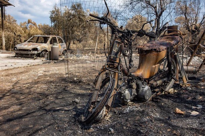 19 August 2021, Greece, Evia Island: A burnt motorcycle and car are pictured near Agia Anna, after wildfires kept burning almost for 10 days. Photo: Nik Oiko/SOPA Images via ZUMA Press Wire/dpa