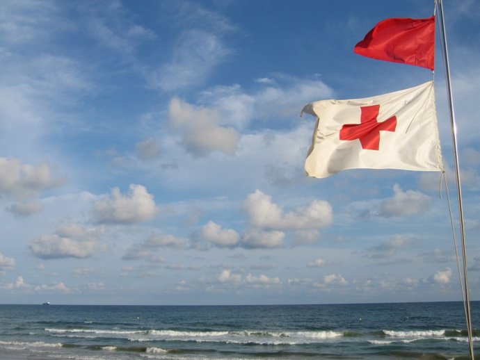 Archivo - Una bandera de Cruz Roja ondea al viento en Murcia. Playas, salvamento. Socorrismo. Bandera roja