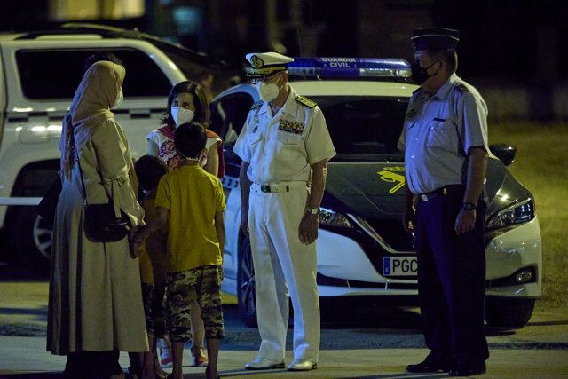 La ministra de Defensa, Margarita Robles (rojo-d), y el JEMAD, Teodoro López Calderón (blanco-d), reciben a las personas repatriadas a su llegada a la Base Aérea de Torrejón tras bajarse del séptimo avión procedente de Afganistán