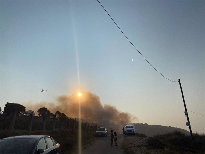Un helicóptero trata de apagar el fuego declarado en Razo, en Carballo