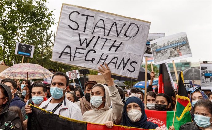 22 August 2021, Hamburg: Participants hold signs during a demonstration held to call for the the reception of stranded Afghan people following the Taliban takeover. Photo: Markus Scholz/dpa