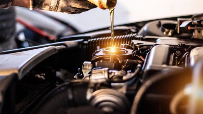 Mecánico poniendo aceite en un motor