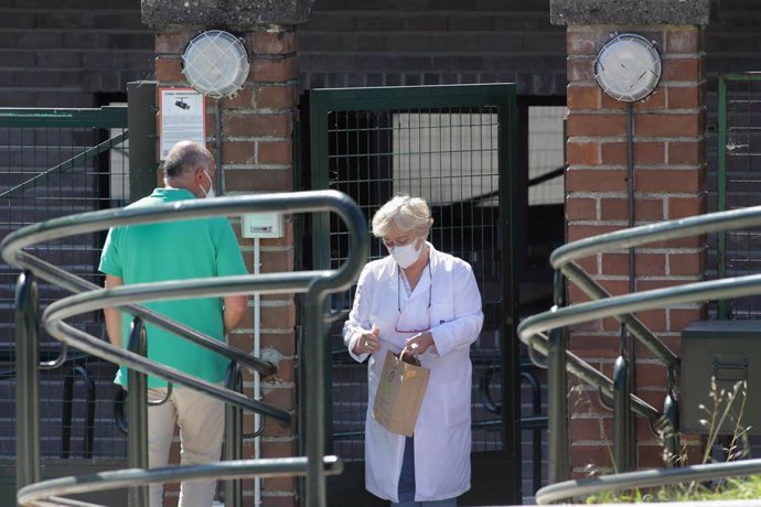 Una trabajadora atiende a un familiar en la puerta de la residencia de As Gándaras de Lugo, en agosto de 2021.