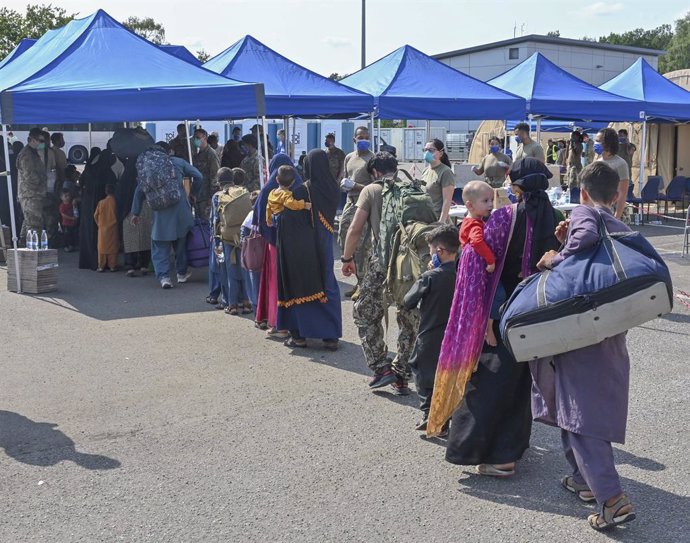 21 August 2021, Rhineland-Palatinate, Ramstein-Miesenbach: Afghan refugees evacuated from Kabul line up for processing after arrival from Kabul at Ramstein Air Base. Ramstein Air Base provides temporary housing for evacuees from Afghanistan as part of O