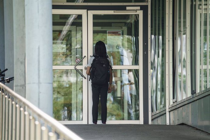 24 August 2021, Hessen, Darmstadt: A man stands at the entrance to building L201 on the Lichtwiese campus at the Lichtwiese campus of Darmstadt University of Technology following the incident of poisoning of six people. The police in the German city of 