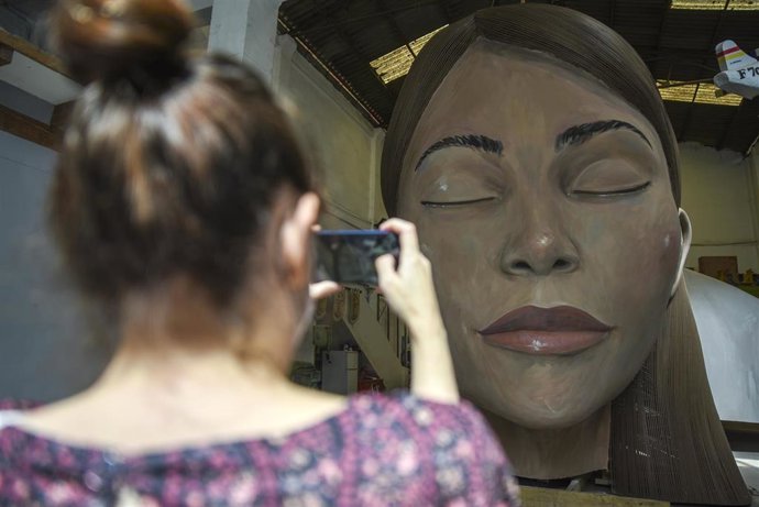 Una mujer fotografía el busto de 'La Meditadora' en el taller de sus artistas falleros. 