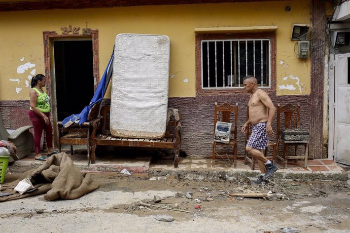 Archivo - 25 June 2021, Venezuela, Caracas: A man clears everything out of his house after the previous day's floods due to heavy rainfall. Photo: Pedro Rances Mattey/dpa