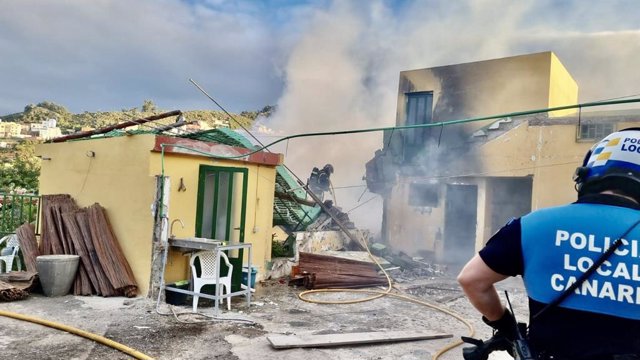 Un agente de la Policía Local de La Laguna observa el derrumbe de una vivienda tras un incendio