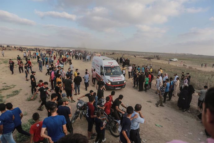 21 August 2021, Palestinian Territories, Gaza: Palestinian protesters evacuate injured youths amid clashes with Israeli security forces following a demonstration at the border fence with Israel, denouncing the Israeli siege of the Palestinian strip. Pho