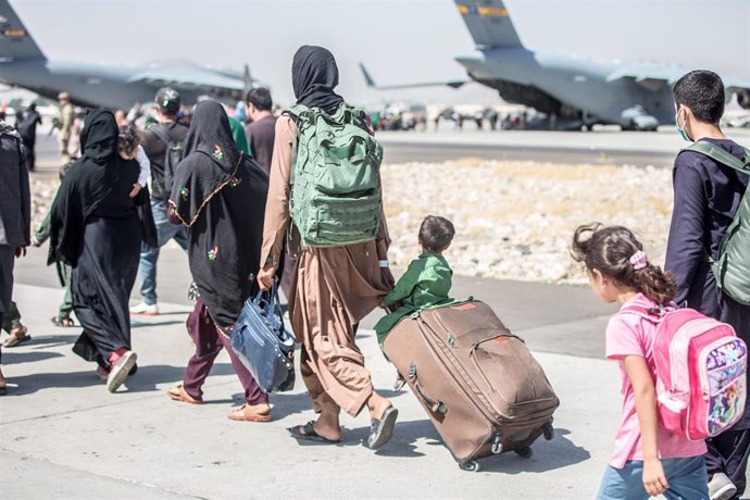 Un grupo de personas se dirigen a un avión durante una evacuación en el aeropuerto de Kabul