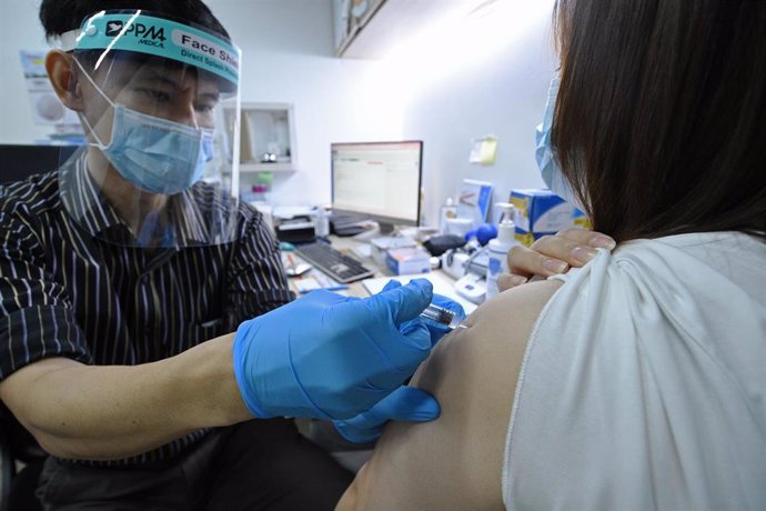 Un doctor inocula la vacuna china Sinovac contra el coronavirus en un centro médico de Singapur.