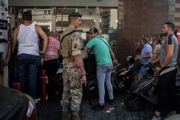 14 August 2021, Lebanon, Beirut: A Lebanese army soldier supervises entry of motorists and vehicles at a gas station in Beirut to curb fuel hoarding, as central bank chief Riad Salamehannounced this week that he would no longer be able to subsidize fue