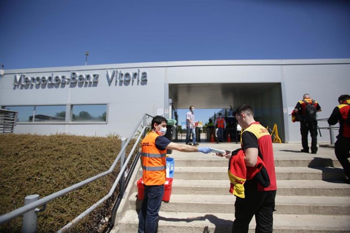 Archivo - Un trabajador de la planta de Mercedes-Benz de Vitoria recibe una mascarilla a su entrada a las instalaciones. En Vitoria (Álava), a 18 de mayo de 2020.
