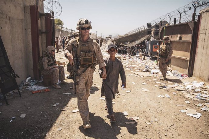 HANDOUT - 24 August 2021, Afghanistan, Kabul: A US marine escorts an Afghan child to his family during an evacuation at Hamid Karzai International Airport following the Taliban takeover. Photo: Ssgt. Victor Mancilla/U.S. Marin/Planet Pix via ZUMA Press 