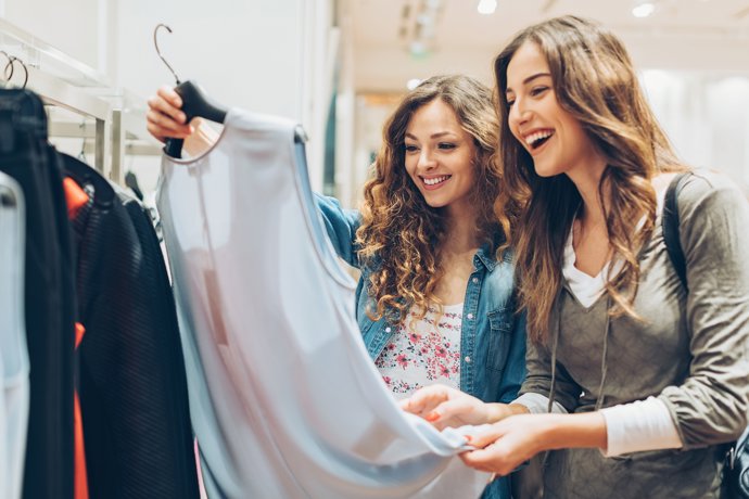 Dos chicas en una tienda mirando ropa