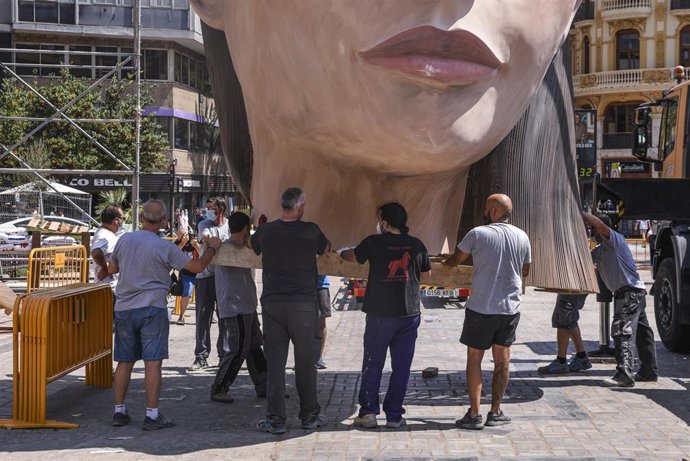 Varios trabajadores colocan la falla de La Meditadora, en la plaza del Ayuntamiento de Valncia