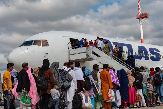 24 August 2021, Rhineland-Palatinate, Ramstein-Miesenbach: Afghan refugees board a commercial plane for USA from Kabul at Ramstein Air Base after being evacuated from Afghanistan in the aftermath of the Taliban takeover. Photo: Airman Edgar Grimaldo/U.S