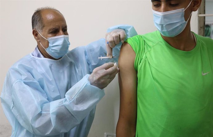 26 August 2021, Palestinian Territories, Deir Al Balah: A medic injects a man with a dose of the anti-coronavirus Covishield vaccine at a temporary vaccination centre during a vaccination campaign. Photo: Ashraf Amra/APA Images via ZUMA Press Wire/dpa