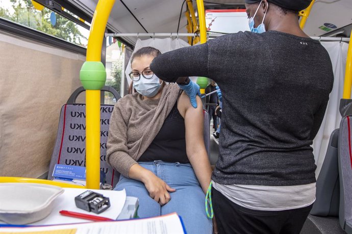20 August 2021, North Rhine-Westphalia, Boenen: A woman receives a coronavirus vaccine at a vaccination bus in the courtyard of the Boenen community centre. Photo: David Inderlied/dpa