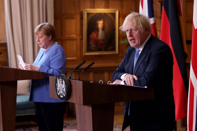 Archivo - 02 July 2021, United Kingdom, Buckinghamshire: UK Prime Minister Boris Johnson (R) and German Chancellor Angela Merkel, hold a joint press conference after their meeting at Chequers, the country house of the Prime Minister of the United Kingdo