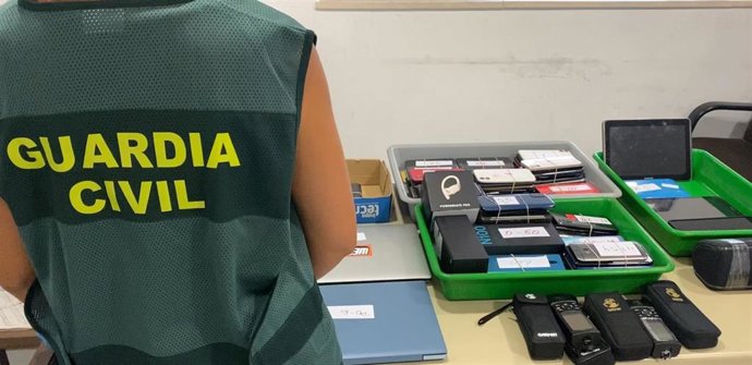 Un agente de la Guardia Civil con los objetos intervenidos a la mujer detenida.