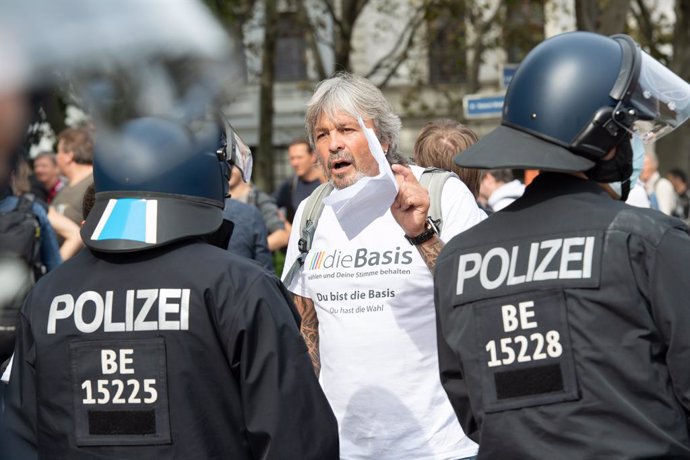 28 August 2021, Berlin: Policemen argue with a man during a protest against coronavirus-related policies. Photo: Paul Zinken/dpa