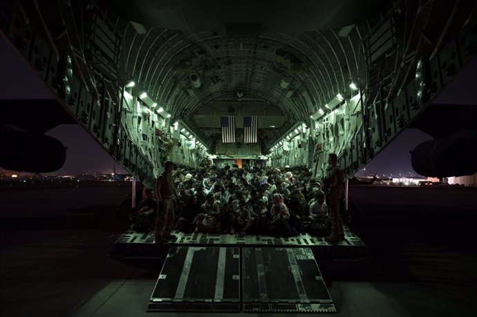 HANDOUT - 21 August 2021, Afghanistan, Kabul: Soldiers from the United States Air Force 816th Expeditionary Airlift Squadron stand next to Afghan passengers being evacuated from Kabul aboard a Boeing C-17 following the Taliban takeover. Photo: U.S. Air 