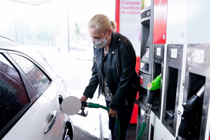 Archivo - Una mujer pone gasolina a su vehículo en una gasolinera