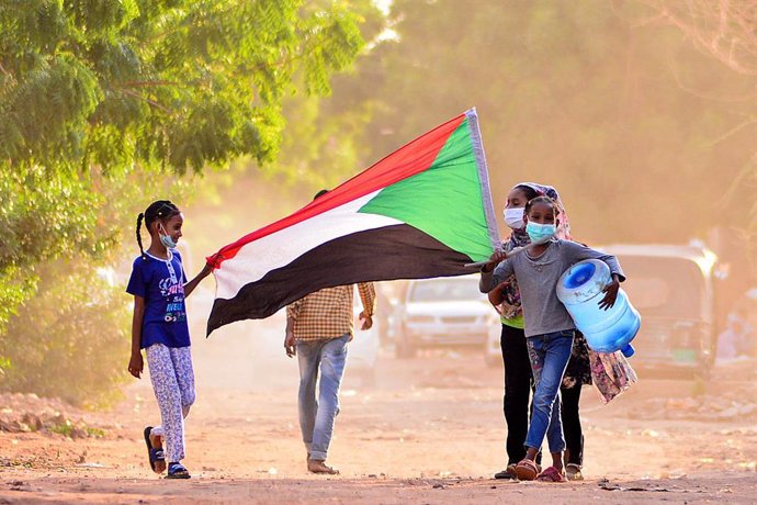 Archivo - Ciudadanos de Sudán con la bandera del país