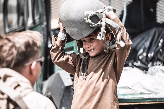 HANDOUT - 22 August 2021, Afghanistan, Kabul: A US marine soldier plays with a young child at the Hamid Karzai International Airport during the evacuation of civilians following the Taliban takeover. Photo: -/U.S. Marines via ZUMA Press Wire Service/dpa