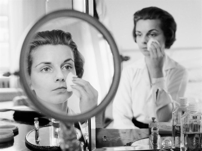 Archivo - Circa 1955:  A woman rubbing her face with cotton wool to remove make up or apply moisturiser.  (Photo by Jacobsen /Three Lions/Getty Images)