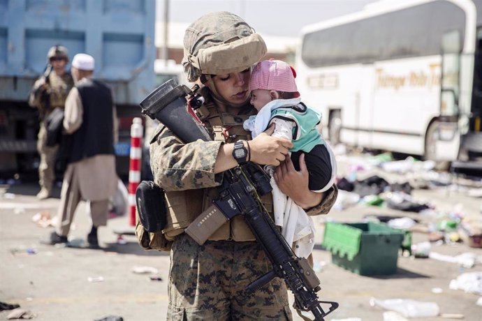 Una miembro de las fuerzas estadounidenses con un bebé en el aeropuerto de Kabul, la capital de Afganistán. 