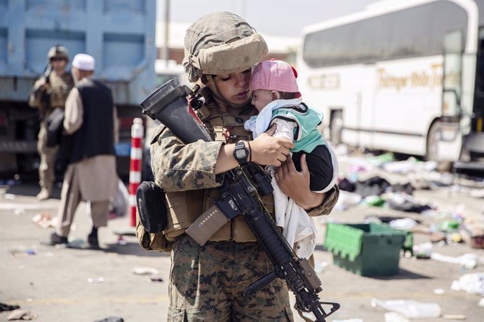 28 August 2021, Afghanistan, Kabul: Asoldier of the Special Purpose Marine Air-Ground Task Force Crisis Response team, calms an infant waiting for evacuation at Hamid Karzai International Airport during Operation Allies Refuge in Kabul. Photo: Ssgt. Vi
